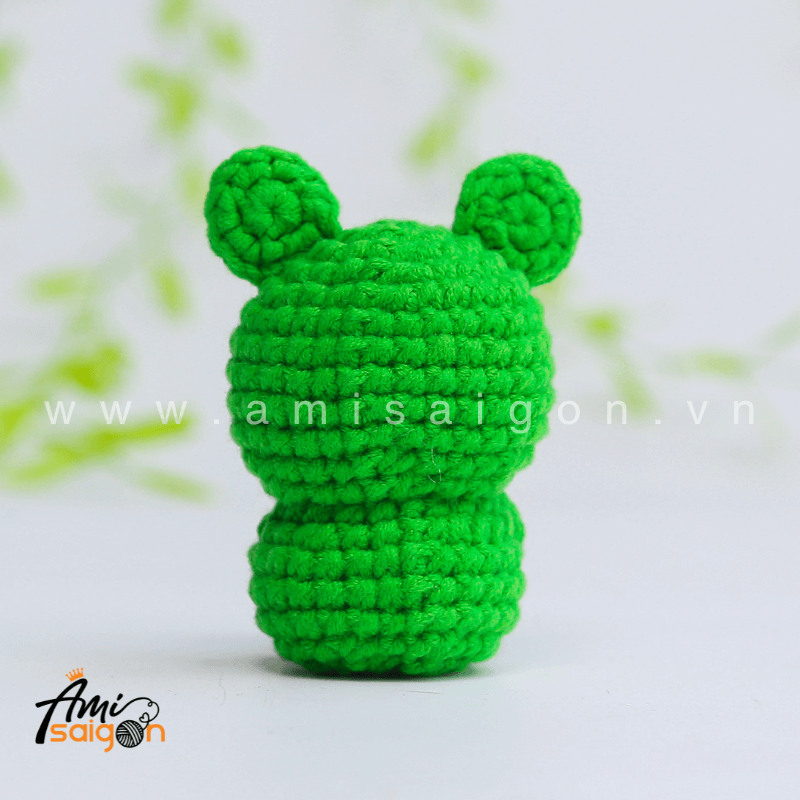 Cute frog amigurumi facing forward with black eyes and a sweet handmade crochet look