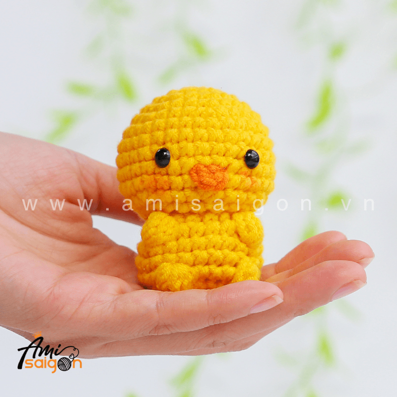 Tiny chicken amigurumi held in hand